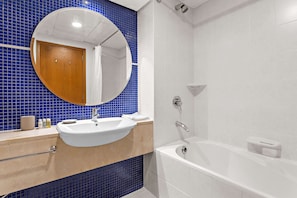 A bathroom with a white sink, a bathtub, and a mirror. - Silkhaus 21st Century, DIFC Dubai (Dubai)
