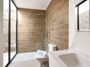 A modern bathroom with a shower, toilet, and bathtub.