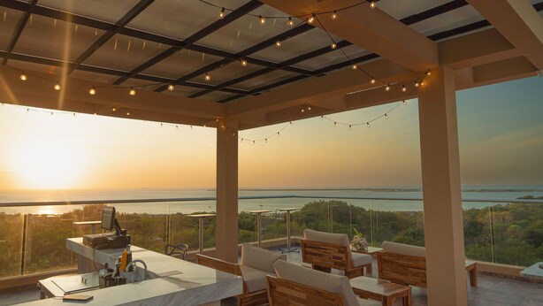 A terrace with a view of the sea, equipped with a bar and seating.
