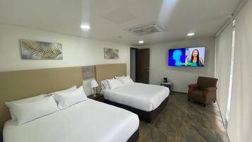 Habitación de hotel con dos camas, un televisor, una silla y obras de arte en las paredes.
