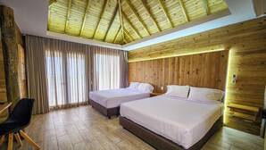 A room with two beds, a desk, and a chair.