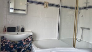 A bathroom with a white sink, a mirror, a shower with a glass door, and a bathtub.