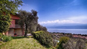 Propriedade numa encosta com vista para um lago e montanhas ao longe.