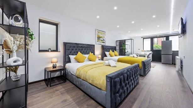 Una camera da letto moderna con un letto grande, comodini, uno specchio e una TV.