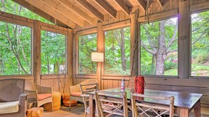 A wooden deck with wicker furniture, a table, and chairs. - Luxe Rumbling Bald Home w/ Deck & Mountain View (Lake Lure)