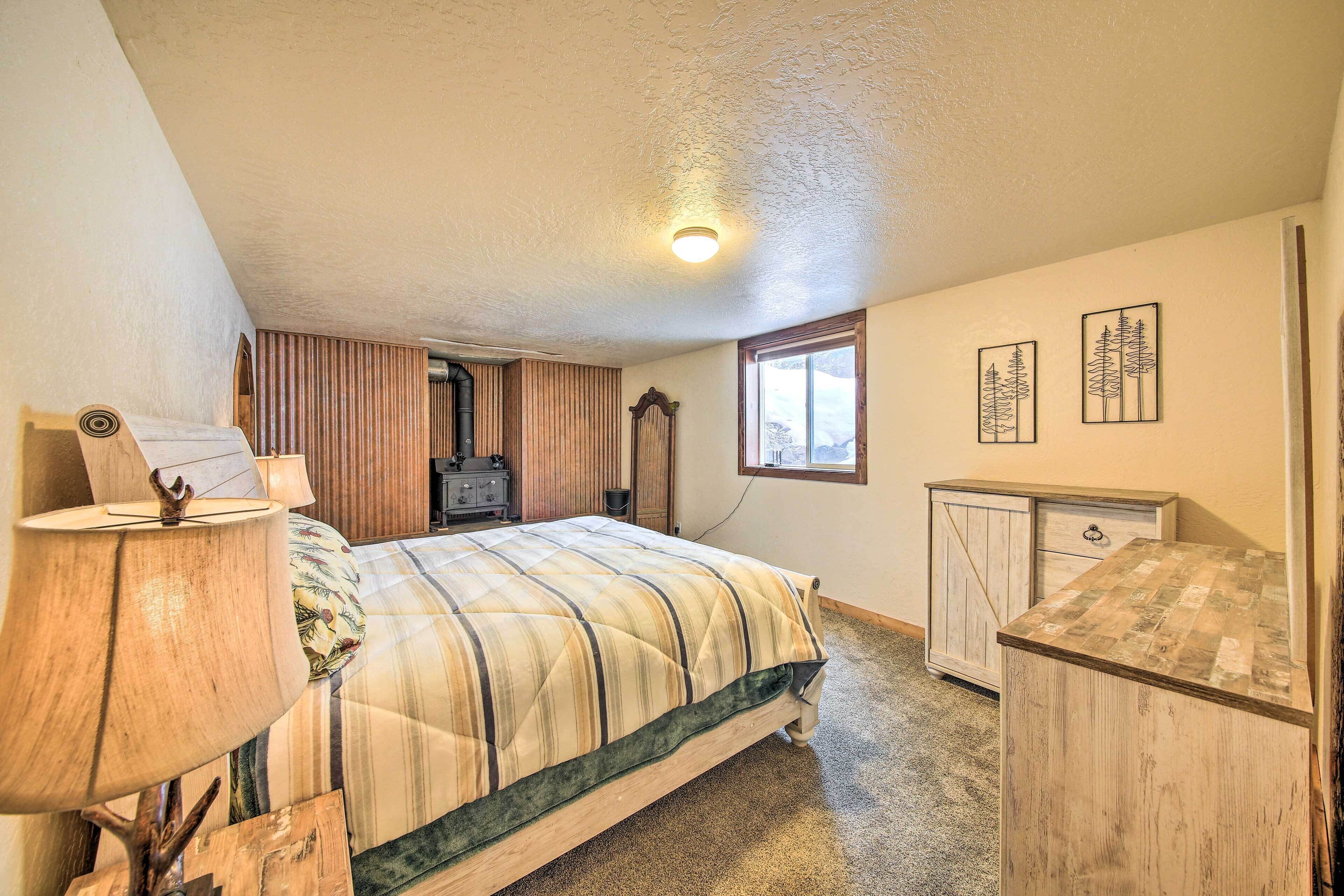 Une chambre à coucher avec un lit, une commode, une lampe et une fenêtre.