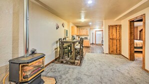 A cozy interior with a wood-burning stove, a dining area, and a kitchen. - Priest Lake Apartment Near Hiking Trails! (Priest River)