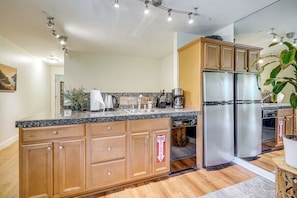 A modern kitchen with wooden cabinets, a stainless steel refrigerator, and a built-in dishwasher. - < 3 Mi to Lake Tahoe: Incline Village Condo! (Incline Village)