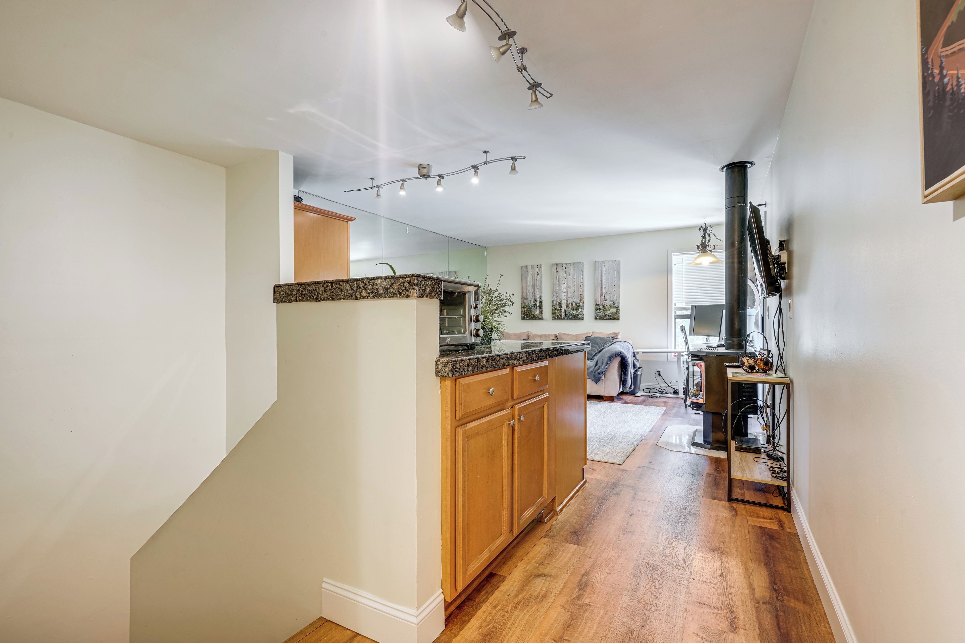 A modern kitchen with wooden cabinets, a granite countertop, and a built-in oven.