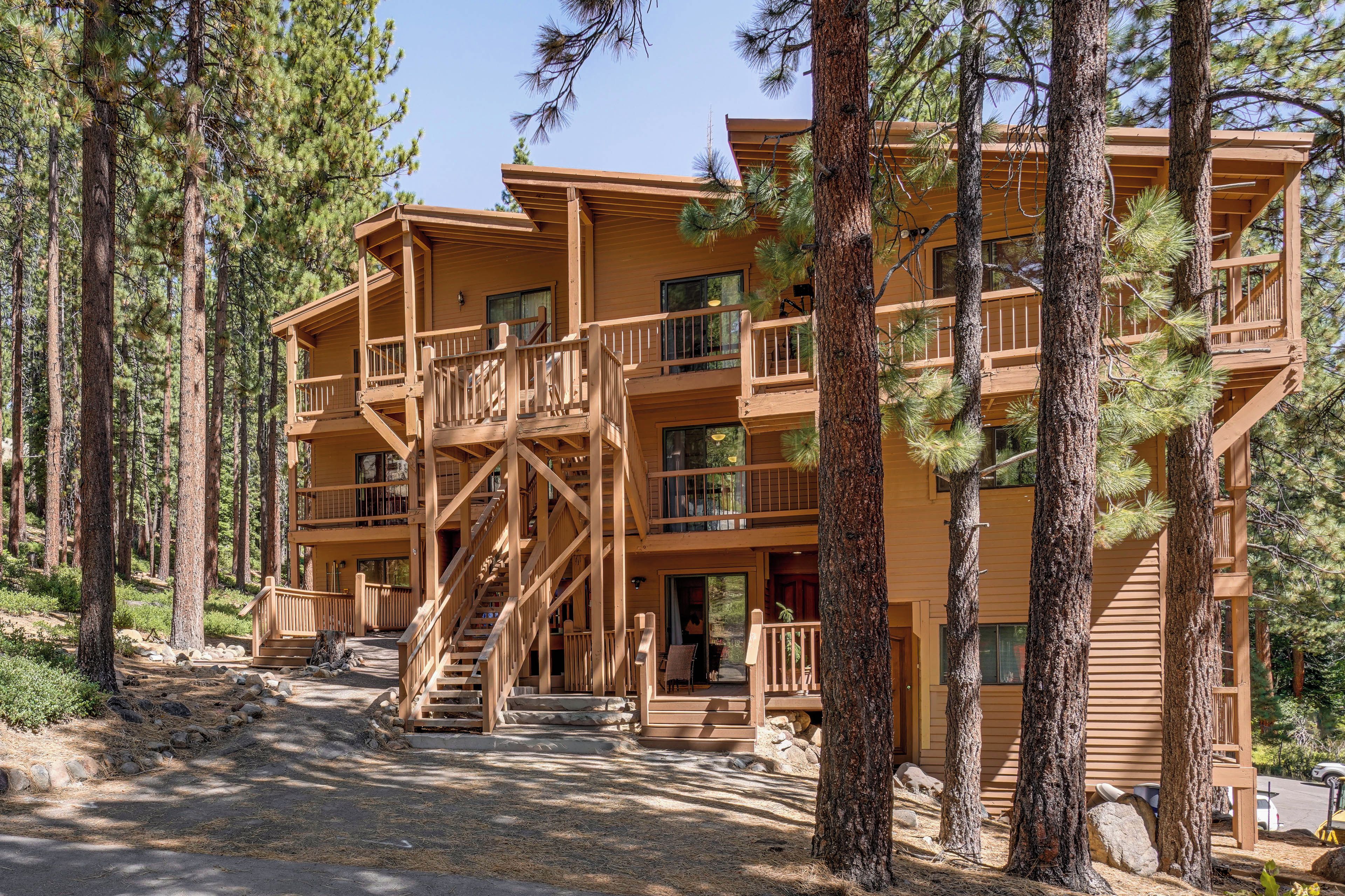 A multi-story lodge with a wooden exterior, multiple balconies, and a central staircase.