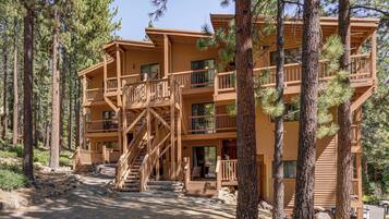 A multi-story lodge with a wooden exterior, multiple balconies, and a central staircase.