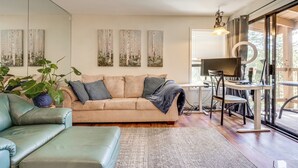 A modern living room with a beige sofa, a green armchair, and a small table with a computer setup. - < 3 Mi to Lake Tahoe: Incline Village Condo! (Incline Village)