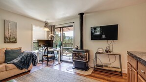 A cozy living room with a fireplace, a television, and a dining area with a view. - < 3 Mi to Lake Tahoe: Incline Village Condo! (Incline Village)