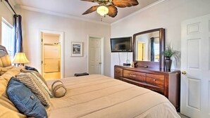 A bedroom with a bed, a wooden dresser, a television, and a ceiling fan. - South Padre Island Condo w/ Pool Access & Balcony! (South Padre Island)
