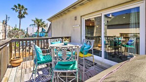 A deck with outdoor furniture, including chairs and a table, overlooking a beach. - South Padre Island Condo w/ Pool Access & Balcony! (South Padre Island)