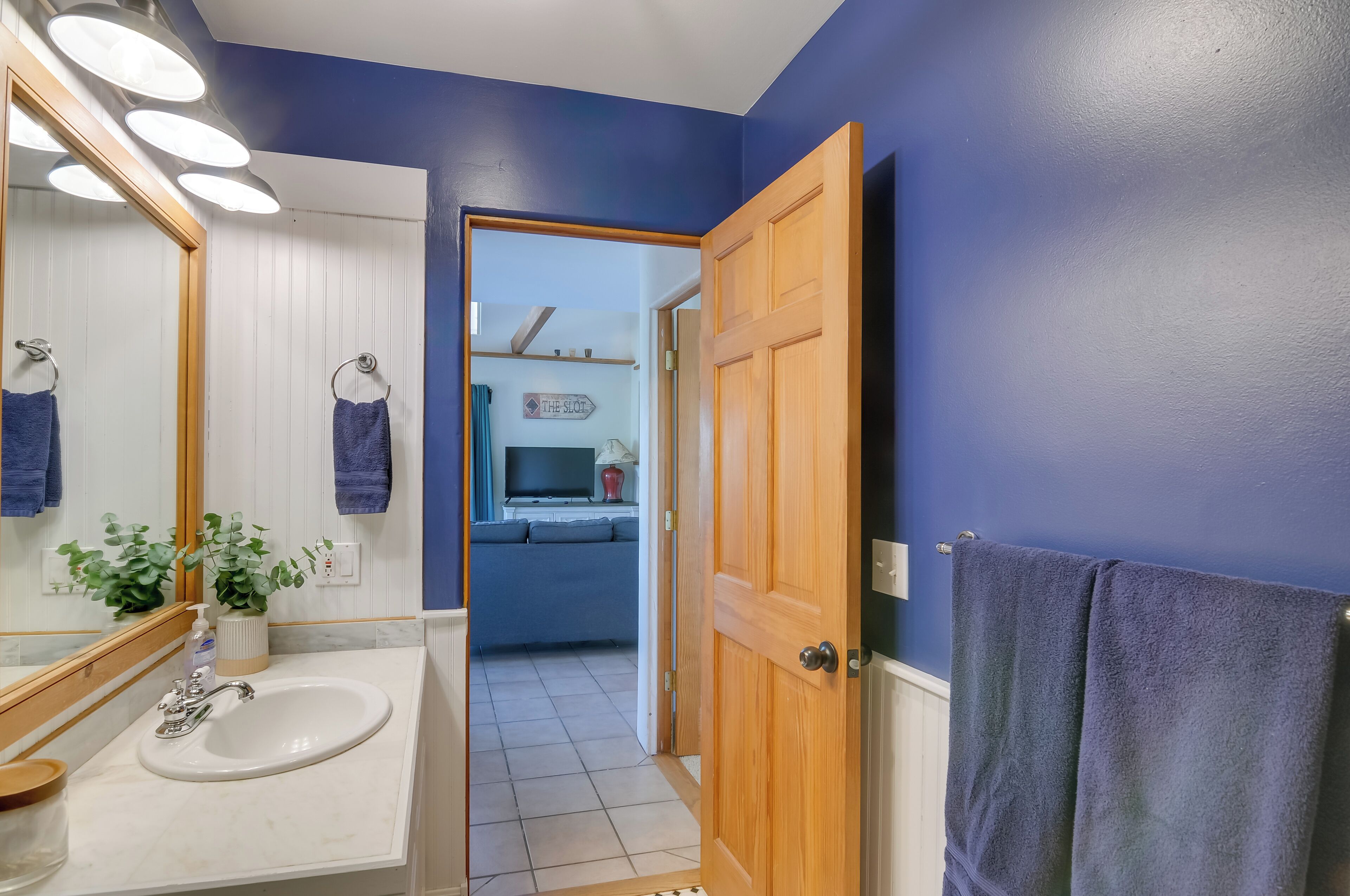 A bathroom with a sink, mirror, and towel rack.