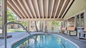 A covered outdoor swimming pool with a wooden deck, lounge chairs, and a clear view of the surrounding area. - Elegant Mountain-view Condo < 1 Mi to Lifts! (Mammoth Lakes)