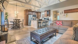 A spacious living area with a large sofa, a dining table with chairs, and a kitchen area with modern appliances. - Elegant Mountain-view Condo < 1 Mi to Lifts! (Mammoth Lakes)