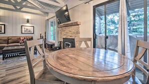 A wooden dining table with chairs, a fireplace, and a TV mounted on the wall. - Elegant Mountain-view Condo < 1 Mi to Lifts! (Mammoth Lakes)