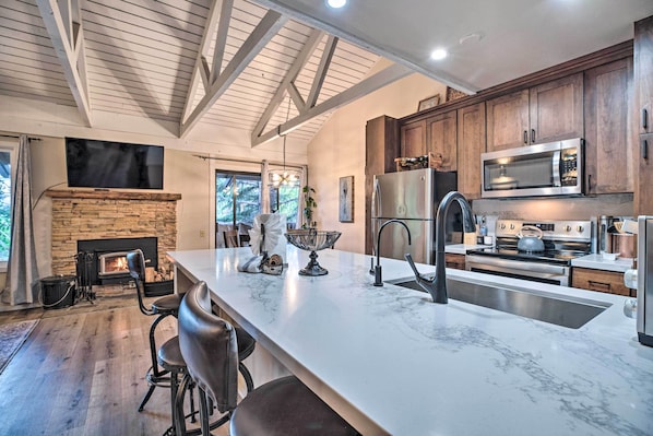A spacious kitchen with a large island, wooden cabinets, and modern appliances.