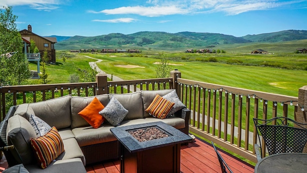 A deck with a sofa and a fire pit, overlooking a golf course and hills. - Mtn-view Gem w/ On-site Golf! 3 Mi to Granby Ranch (Granby)