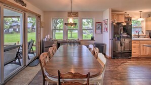 A spacious kitchen with a large dining table, wooden cabinets, and a built-in refrigerator. - Bright Shawano Lake Oasis - Walk to Boat Launch! (Cecil)