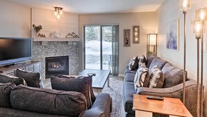A modern living room with a fireplace, a flat-screen TV, and a sofa set. - Frisco Condo w/ 2 Hot Tubs: Steps to Lake Dillon (Frisco)