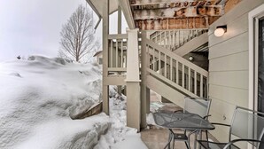 A covered outdoor area with a metal table and chairs, a wooden staircase, and a snow-covered landscape. - Frisco Condo w/ 2 Hot Tubs: Steps to Lake Dillon (Frisco)
