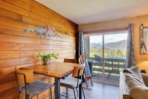 A wooden-paneled room with a dining table, chairs, a plant, and a view of mountains through a sliding glass door. - 4 Mi to Marina: Family Townhome in Silverthorne! (Silverthorne)