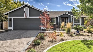 A modern two-story house with a garage, a well-maintained garden, and a clear sky. - Large Yard + Hot Tub: Reno Retreat! (Reno)