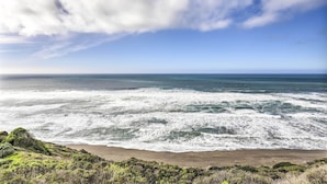 A beach with waves and a clear sky.