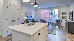 A modern kitchen with a large island, pendant lighting, and a view to the outside. - Downtown Traverse City Condo: 32 Mi to Ski Slopes! (Traverse City)