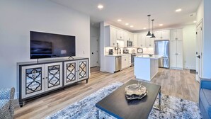 A modern kitchen with white cabinets, a central island, and a built-in microwave. - Downtown Traverse City Condo: 32 Mi to Ski Slopes! (Traverse City)