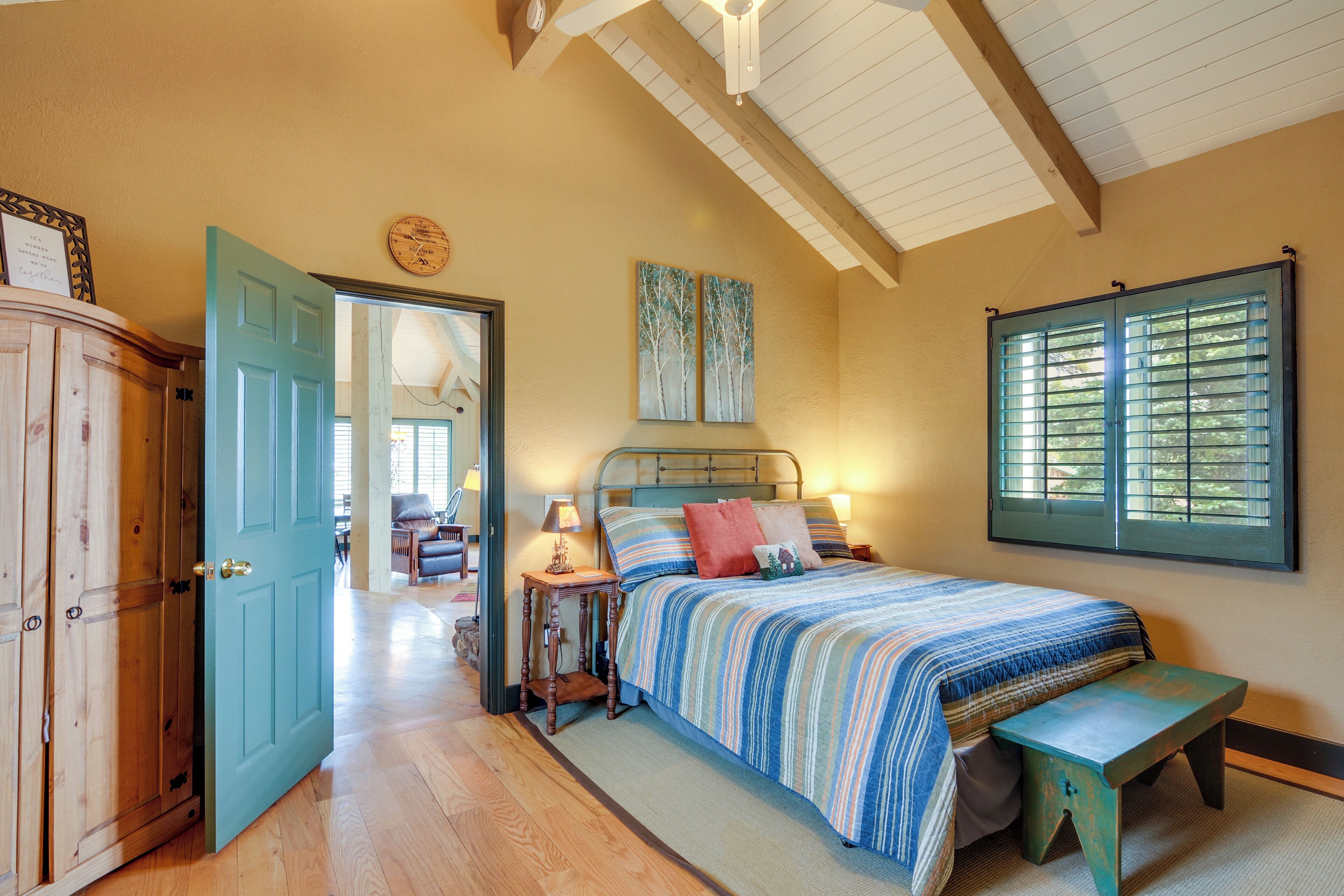 A bedroom with a bed, bedside tables, a bench, and a wardrobe.