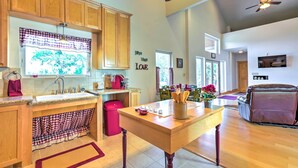 Una cocina amplia con armarios de madera, una isla central y un comedor con sofá de cuero.