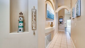 A hallway with a welcome sign, a decorative lighthouse, and framed artwork on the walls. - 11 Mi to Disney: Family-friendly Home in Davenport (Davenport)