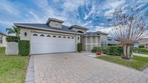 A residential house with a paved driveway, garage, and a well-maintained lawn. - 11 Mi to Disney: Family-friendly Home in Davenport (Davenport)