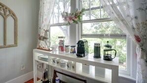 Un plan de travail de cuisine avec une machine à café, une bouilloire et une théière.