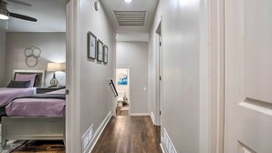 A narrow hallway with a bed on the left, a ceiling fan, and a door at the end. - Atlanta Retreat w/ Deck in Greenbriar Area! (Atlanta)
