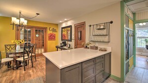 A kitchen with a large island, wooden chairs, a coffee bar sign, and a dining table with chairs. - 2 Mi to Central Ave: Quaint Hot Springs Home! (Hot Springs)