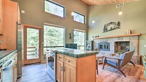 Una cocina amplia con armarios de madera, una isla central y grandes ventanales con vistas al exterior.