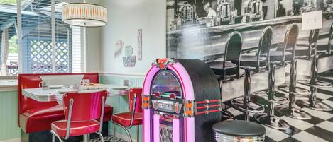 A diner with red booths, a jukebox, and a checkered floor.