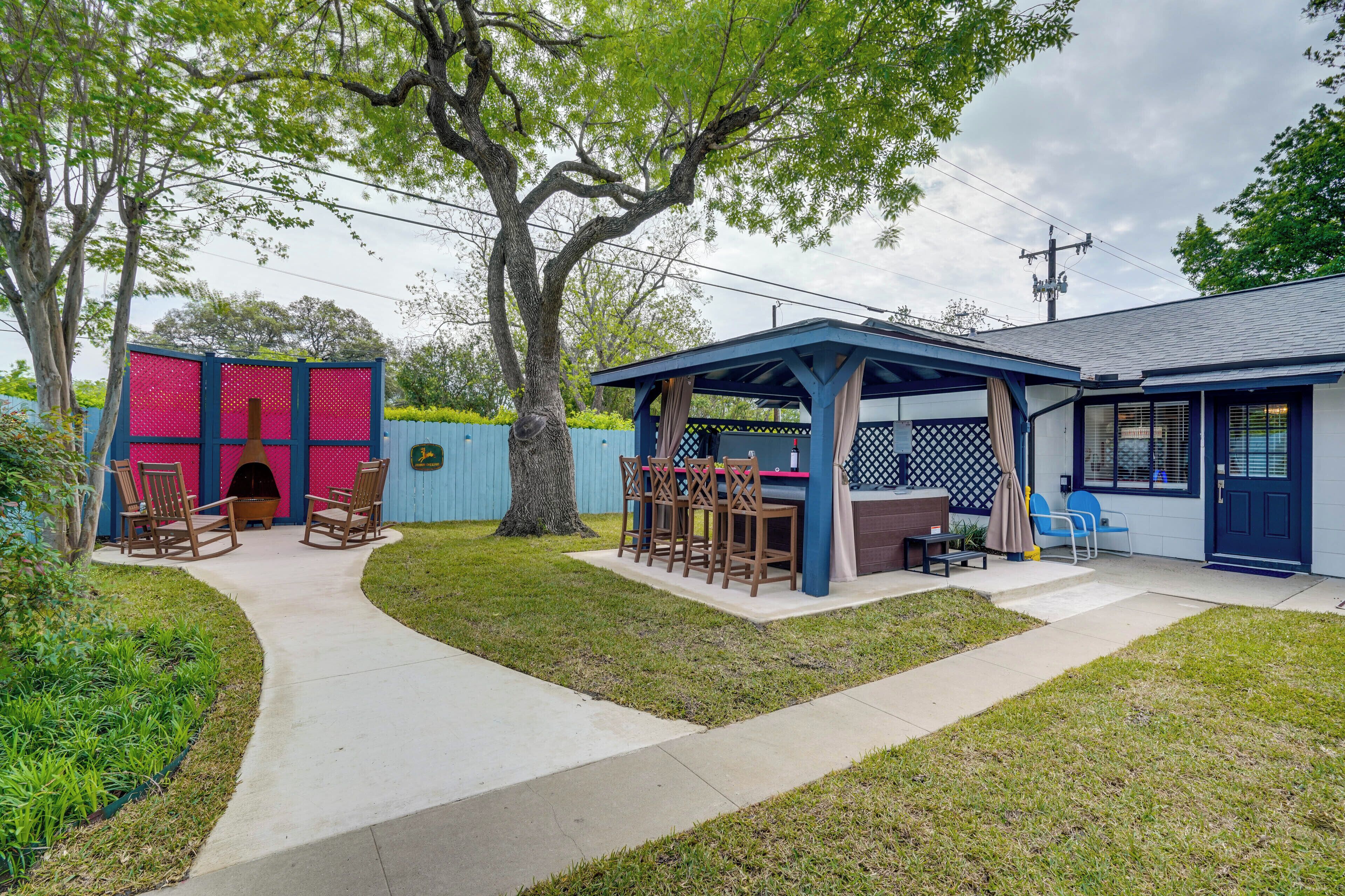 Un patio trasero con una zona de estar cubierta, una parrilla y un cobertizo pequeño.
