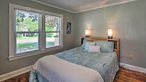 A bedroom with a bed, two bedside lamps, a window with blinds, and a view of the outdoors. - Hot Springs Home - Walk to Oaklawn Casino! (Hot Springs)