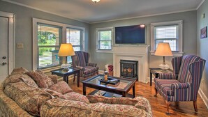 A living room with a sofa, armchairs, a fireplace, and a television. - Hot Springs Home - Walk to Oaklawn Casino! (Hot Springs)