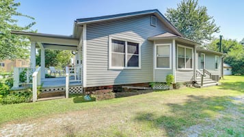 A single-story house with a porch, a small front yard, and a clear sky.