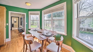 A dining area with a table set for four, large windows, and a view of the outdoors. - Amazing Musical Abode in Expo Square Neighborhood! (Tulsa)