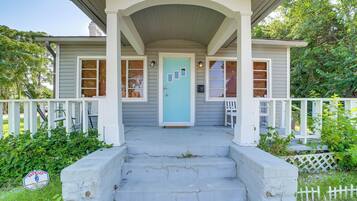 A house with a porch, a blue door, and a white picket fence.