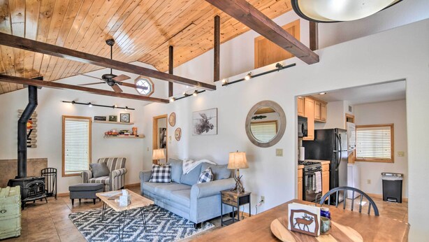 A spacious living room with a fireplace, a sofa, and a dining area with a wooden table.