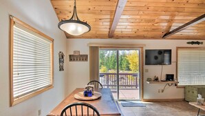 A dining area with a wooden table, chairs, and a ceiling light.
